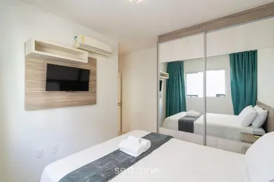 Uma cama ou camas num quarto em Apto 2 suítes e Churrasq. a 550m da Praia EBF0702