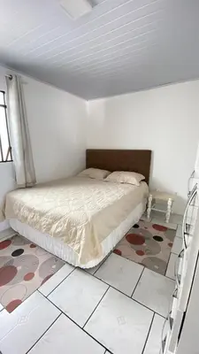 Uma cama ou camas num quarto em Casa 200 metros do mar com churrasqueira