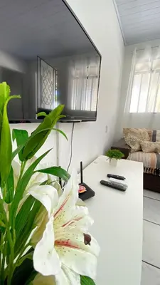 Uma televisão e/ou sistema de entretenimento em Casa 200 metros do mar com churrasqueira