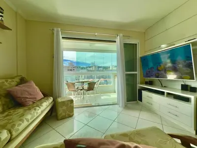 Uma televisão e/ou sistema de entretenimento em Solar de Bombas - Apto 1 quarto - Com toalhas e roupa de cama - Sacada com churrasqueira - climatizado - 5 minutos da a pé da praia de Bombas, 10 min a pé da passarela do Ribeiro ideal para casais ou viajantes solo