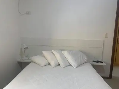 Uma cama ou camas num quarto em Bombinhas Quinta do Mar Complexo A