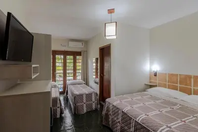 Uma cama ou camas num quarto em Pousada Cores do Mar | Conforto com Piscina em Bombinhas