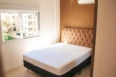 Uma cama ou camas num quarto em temporadabombinhas 2 suítes
