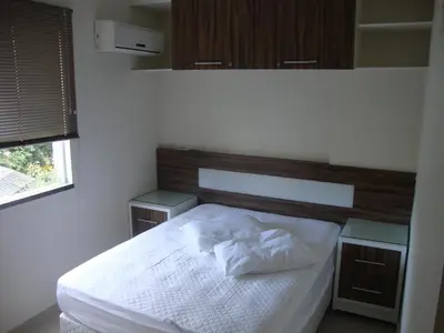 Uma cama ou camas num quarto em apartamento aluguel temporada bombinhas