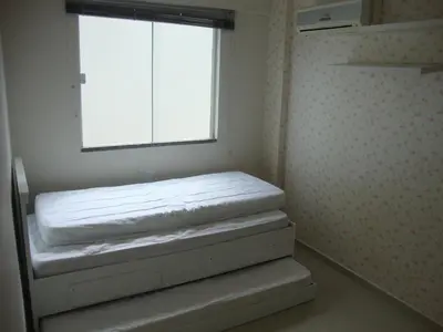 Uma cama ou camas num quarto em apartamento aluguel temporada bombinhas