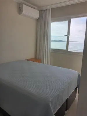 Uma cama ou camas num quarto em Apartamento frente ao mar