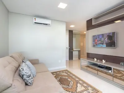 Uma televisão e/ou sistema de entretenimento em Aluguel Apartamento 3 suítes 80m do mar Bombas/SC