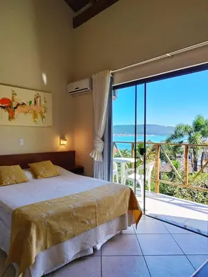 Uma cama ou camas num quarto em Pousada Aquarela de Bombinhas