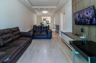 Uma televisão e/ou sistema de entretenimento em Aluguel Apartamento 3 quartos vista mar Bombas SC