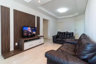 Uma televisão e/ou sistema de entretenimento em Aluguel Apartamento 3 quartos vista mar Bombas SC