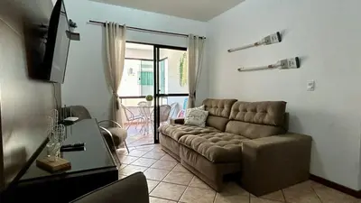 Uma televisão e/ou sistema de entretenimento em Bombas/ Bombinhas, a 50m do Mar, Apartamento 2 quartos, com churrasqueira na sacada, Ar e Wi-fi