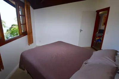 Uma cama ou camas num quarto em BANGALÔ CASA DAS PALMEIRAS - EXCLUSIVIDADE, CONFORTO E PRIVACIDADE.
