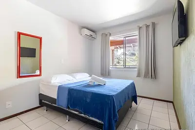 Uma cama ou camas num quarto em Flamboyant Apartamentos Bombinhas