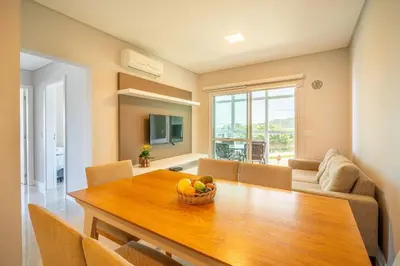 Uma televisão e/ou sistema de entretenimento em Apartamento vista para o mar com 02 dormitórios