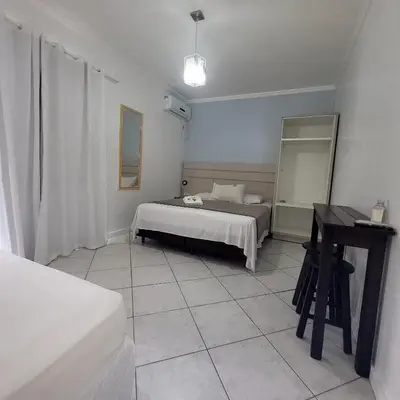 Uma cama ou camas num quarto em Pousada Rota do Sol Bombinhas suíte sem cafe e limpeza - opcional