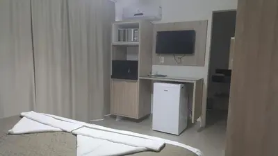 Uma televisão e/ou sistema de entretenimento em Pousada Rota do Sol Bombinhas suíte sem cafe e limpeza - opcional