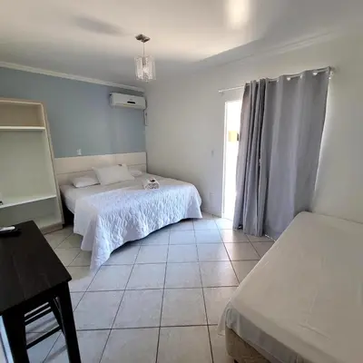 Uma cama ou camas num quarto em Pousada Rota do Sol Bombinhas suíte sem cafe e limpeza - opcional