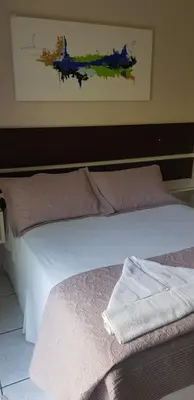 Uma cama ou camas num quarto em Pousada Guaruja