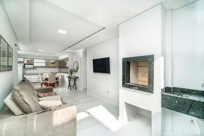 Uma televisão e/ou sistema de entretenimento em Lindo Apartamento com 2 suítes e piscina em Bombas 705