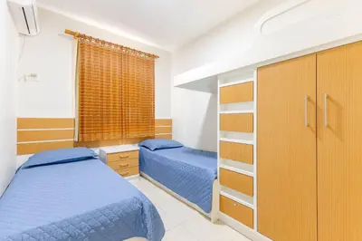 Uma cama ou camas num quarto em Amplo Apartamento a 200m da Praia de Bombas