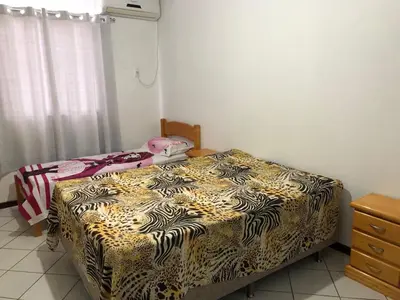 Uma cama ou camas num quarto em apartamento bombinhas