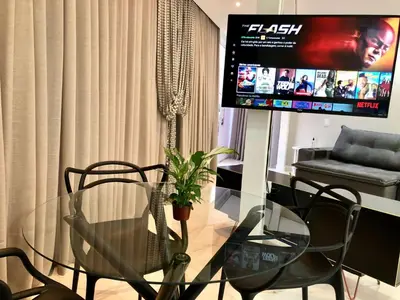 Uma televisão e/ou sistema de entretenimento em Apto Loft Novo - Porto Belo - 5 min a pé da praia
