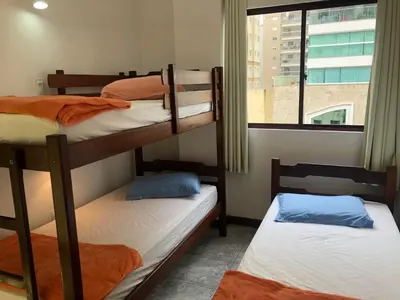 Uma cama ou camas num quarto em UMA QUADRA E MEIA DO MAR Ar Wifi Smart TV