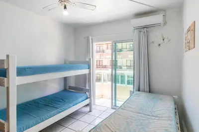 Uma cama ou camas num quarto em 103 Varanda vista mar - 80m da praia - até 10p