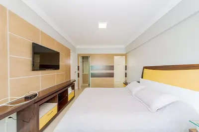 Uma cama ou camas num quarto em Apto Amplo 1SUI+2Q Quadra Mar 50m da Praia