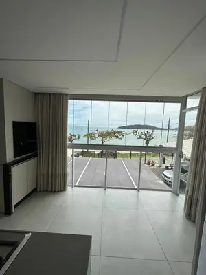 Uma televisão e/ou sistema de entretenimento em Apartamento Frente Mar em Porto Belo