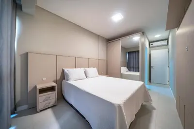 Uma cama ou camas num quarto em Apartamento com duas suítes no centro de Bombinhas