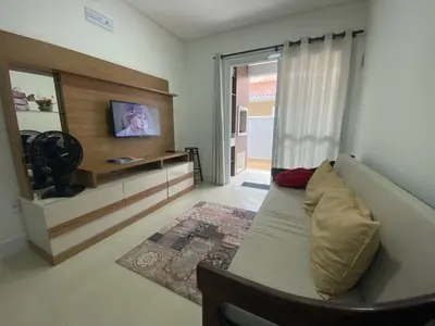 Uma televisão e/ou sistema de entretenimento em Apto na praia de Palmas, climatizado, com piscina, próximo ao mar e com jardim privativo