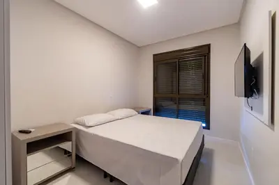 Uma cama ou camas num quarto em Elegante Apartamento no Centro de Bombinhas, 200m da Praia