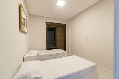 Uma cama ou camas num quarto em Elegante Apartamento no Centro de Bombinhas, 200m da Praia