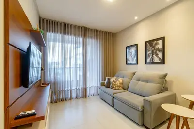 Uma televisão e/ou sistema de entretenimento em Elegante Apartamento no Centro de Bombinhas, 200m da Praia