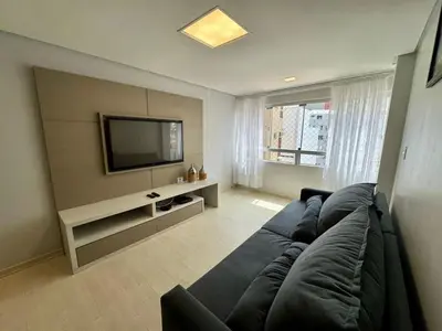 Uma televisão e/ou sistema de entretenimento em Apto 2 Quartos, Ar, garagem e Praia Central a Pé