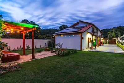 Um jardim no exterior de Charmoso chalé 5min da Praia do Estaleiro Churras&Pet OK
