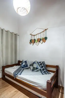 Uma cama ou camas num quarto em Charmoso chalé 5min da Praia do Estaleiro Churras&Pet OK