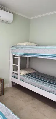 Uma cama ou camas num quarto em APARTAMENTO DE 3 DORM - CANTO GRANDE (BOMBINHAS/SC)