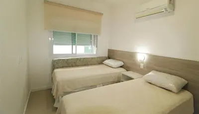 Uma cama ou camas num quarto em 1017 - Praia de Bombinhas locação de temporada - Residencial Egídio Pinheiro Apto 306A