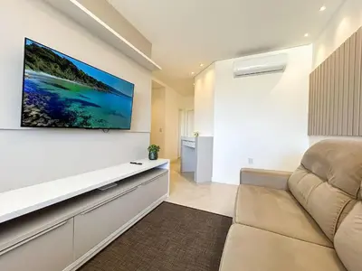 Uma televisão e/ou sistema de entretenimento em Apto NOVO, com piscina, 250m da praia