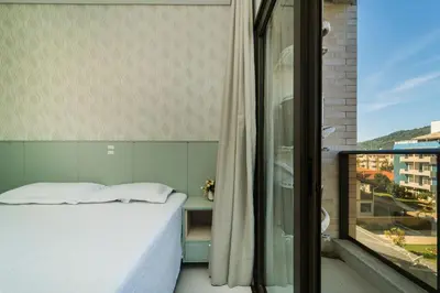 Uma cama ou camas num quarto em Aluguel Apartamento 2 Suítes Bombinhas