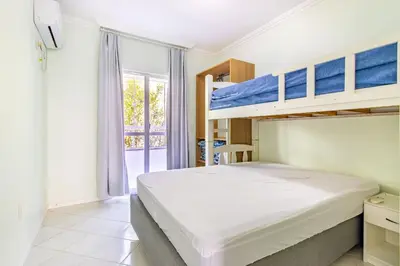 Uma cama ou camas num quarto em 1046 - Praia de Bombinhas locação de temporada - Residencial Solar das Bromélias Apto 121